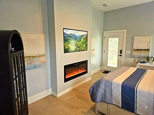 Queen Suite bedroom with electric fireplace, TV, and private entrance